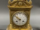 a gold clock sitting on top of a white table