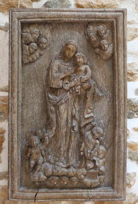 statue d'une femme tenant un enfant sur un mur de pierre