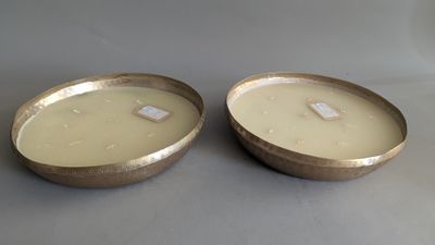 pair of gold metal bowls with lids on a gray surface