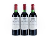 three bottles of red wine sitting next to each other on a white surface
