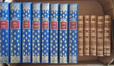six livres dans une boîte en carton posée sur une table, à côté d'autres livres