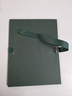a green book with a leather strap on top of it