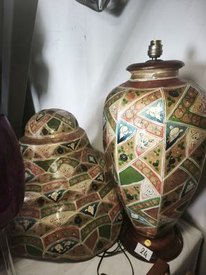 two vases sitting on a table next to a lamp