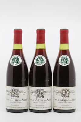 trois bouteilles de vin sont alignées sur une surface blanche