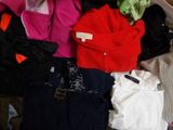 a pile of clothes that is sitting on a bed