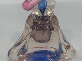 a glass figurine with a pink hat on it