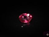 a close up of a pink diamond on a black surface