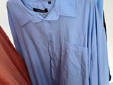 two shirts hanging on a clothes rack in a room