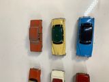 several toy cars are lined up in a row on a white surface