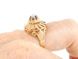 a person holding a gold ring with a diamond on it