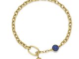 un gros plan sur un bracelet en or orné d'une breloque en pierre bleue