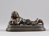 bronze statue of a woman laying on her stomach on a base