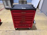 the red tool cart is sitting on the floor in the garage