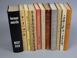 several books are lined up in a row on a gray surface