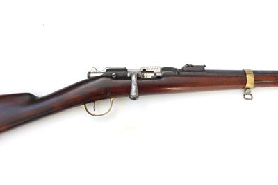 un gros plan d'un fusil posé sur une surface blanche