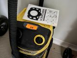 un aspirateur jaune et noir posé par terre à côté d'un livre