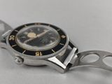 an image of a wrist watch with a black face and gold hands