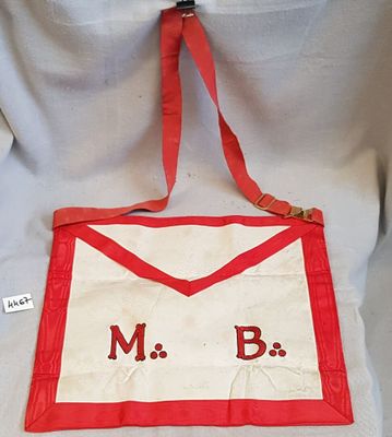 un tablier rouge et blanc sur lequel figurent les lettres « m b »