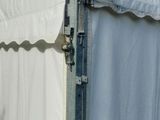 a white tent with a white curtain on the side of it