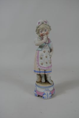 une figurine représentant une petite fille debout sur une boîte