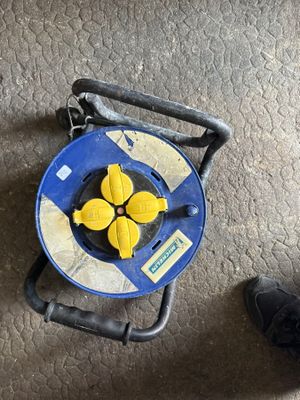 un objet bleu et jaune posé par terre à côté des chaussures d'une personne