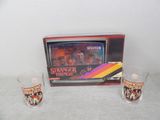 two shot glasses sitting next to a television set