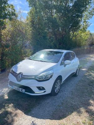 a white car parked on the side of a dirt road