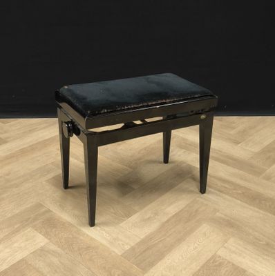une photo d'un piano noir posé sur un parquet en bois massif