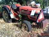 un tracteur rouge assis dans l'herbe