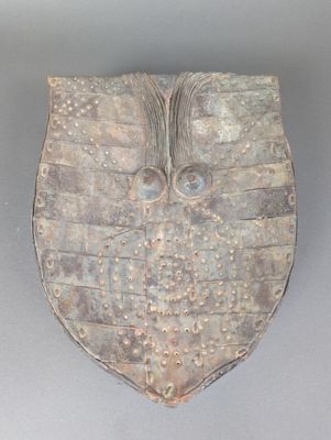 une image représentant un objet décoratif sur lequel figure un visage