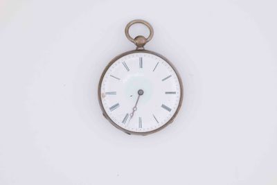 a white clock with roman numerals on the face of it