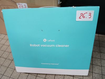 an open box of robot vacuum cleaner sitting on a tiled floor