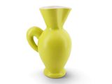 un vase jaune posé sur une surface blanche