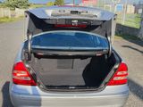 a silver car with its trunk open in the parking lot