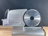 a close up of a slicer sitting on a wooden table