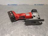 a red and black electric tool sitting on top of a metal surface