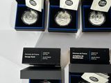 six silver coins are in a black box on a white surface