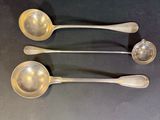 three silver spoons are lined up in a row on a table