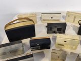 a lot of old radio ' s sitting on a table