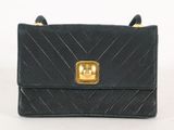 un sac à main noir orné d'une boucle dorée sur le devant