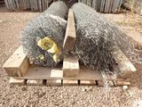 two bales of hay sitting on a pallet in the dirt