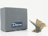 a small figurine of a butterfly sitting next to a box