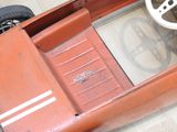 une petite voiture rouge avec un système de direction et un volant