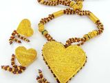 Collier de perles jaunes et rouges avec un pendentif en forme de cœur et des boucles d'oreilles assorties