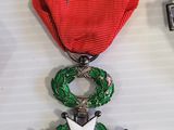 three medals and a cell phone on a table