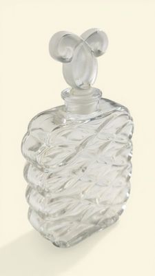a clear glass bottle with a silver top on a white surface