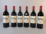 six bouteilles de vin sont alignées sur une table