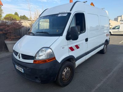 La camionnette blanche est garée sur le parking, à côté d'une clôture.