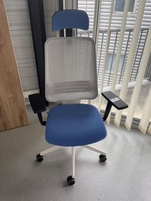 une chaise de bureau bleue et blanche dans un coin de la pièce