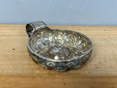 a small silver bowl on a wooden table